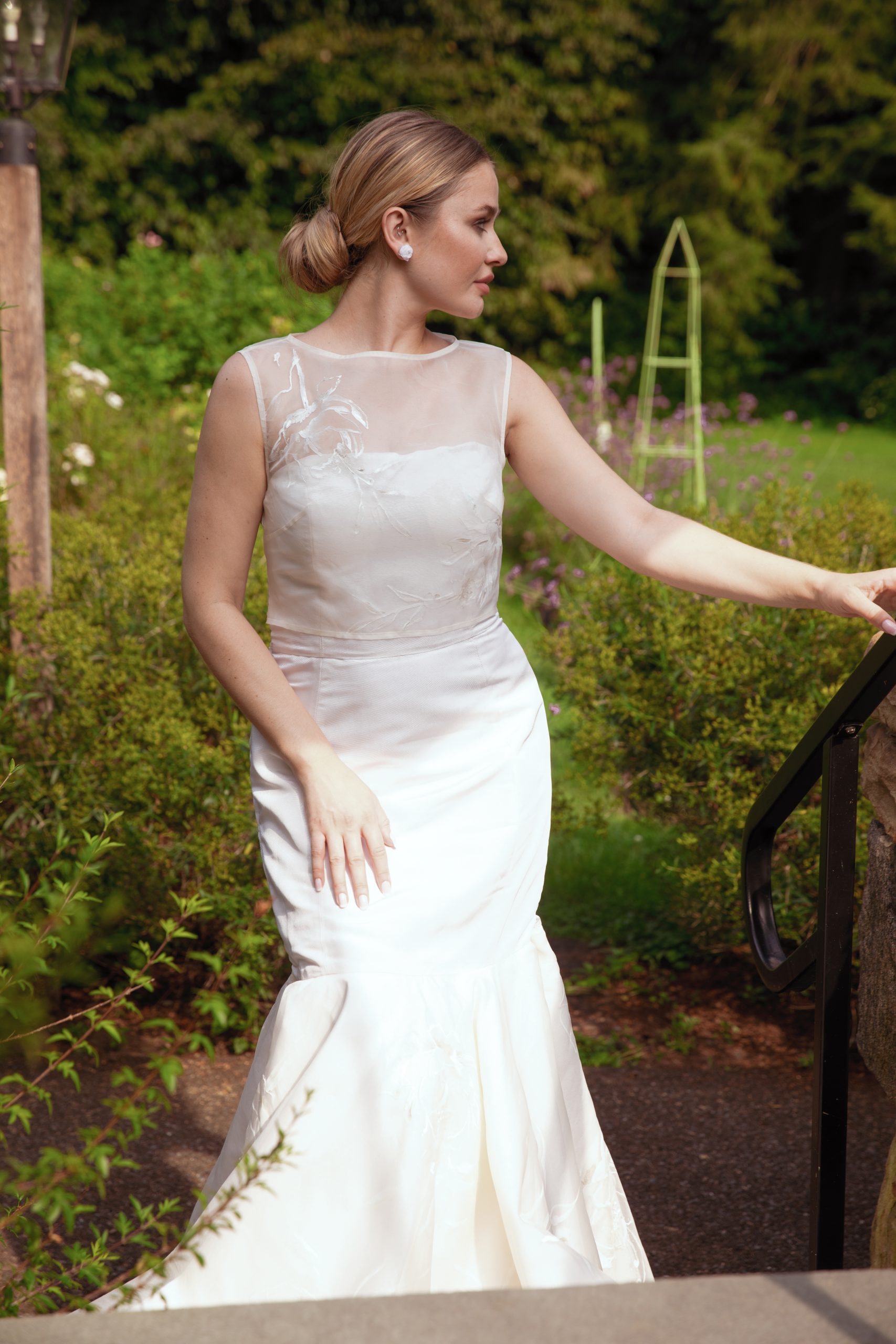 model standing in garden wearing Elegant couture bridal gown