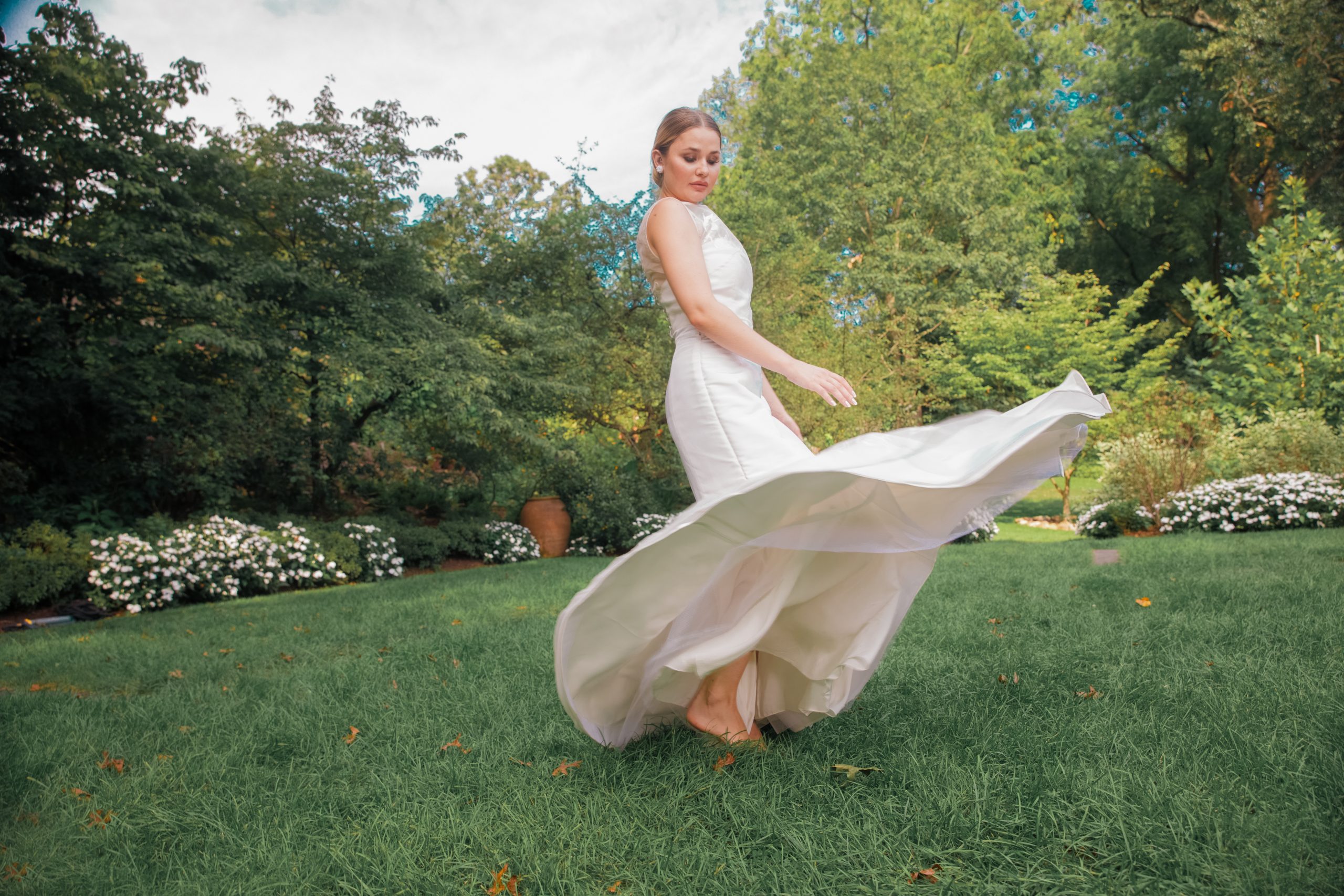 model twriling in Modern trumpet bridal dress with hand painted detailing