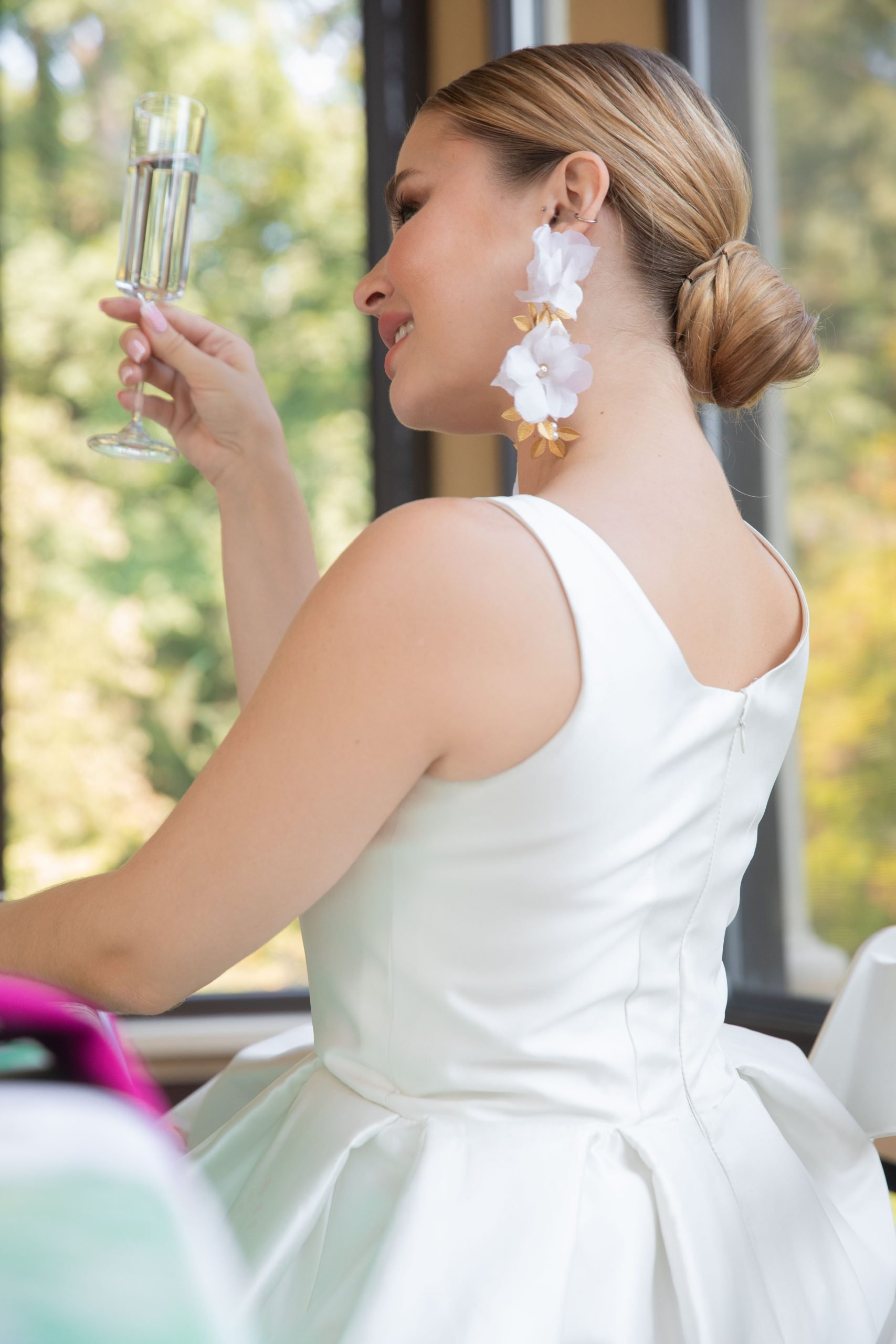 model cheering her wine glass in white mini dress by ZB Couture