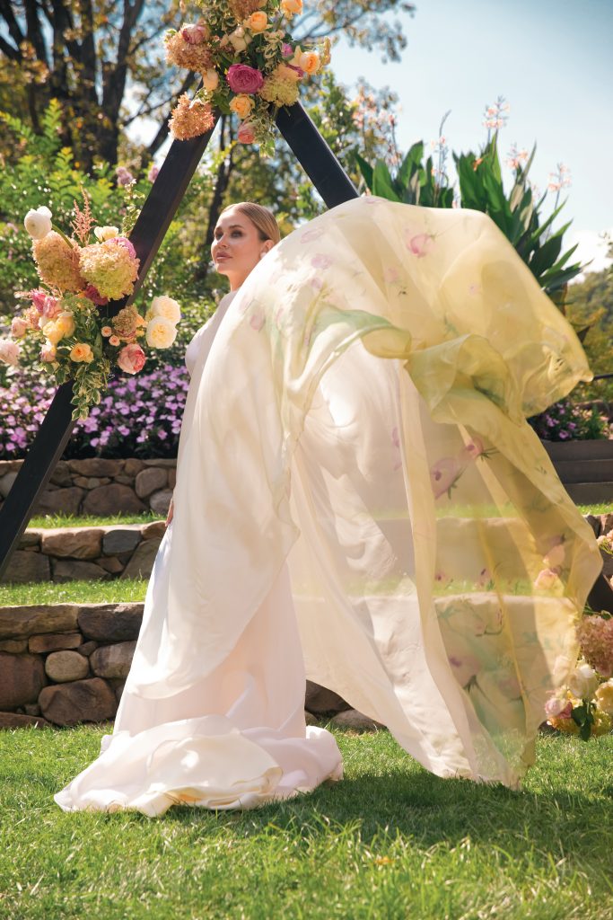 dancing silk bridal cape in setting of floral garden