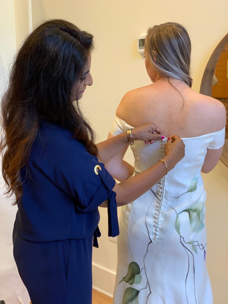 Zahra, owner and designer of ZB Couture helping bride with her wedding dress